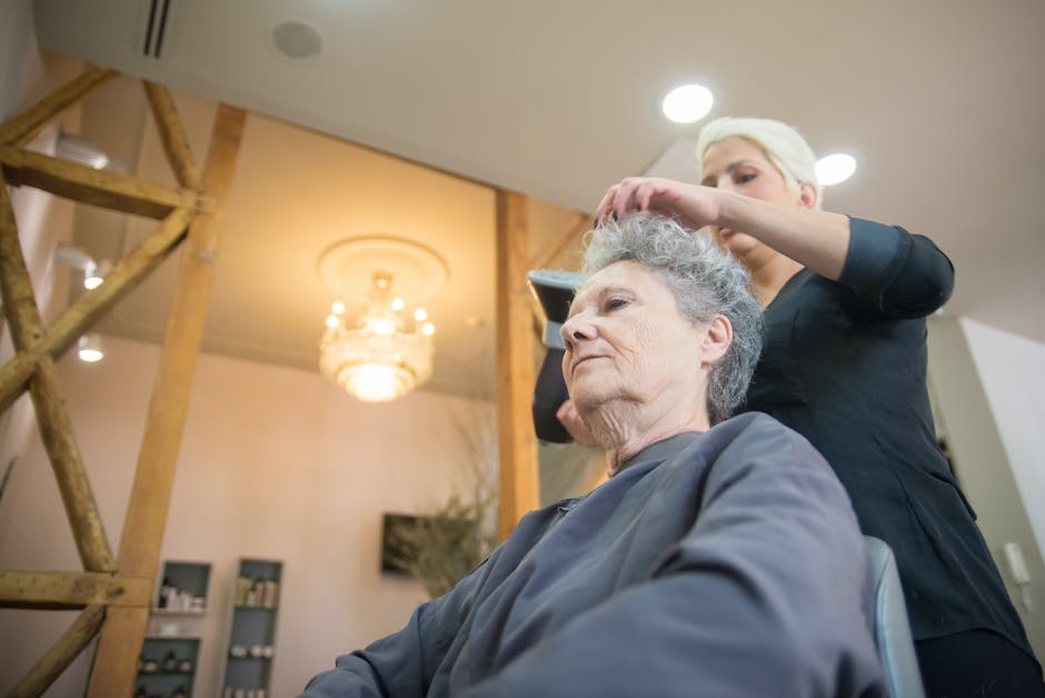 A senior woman having her hair styled by a professional hair stylist in a modern salon
