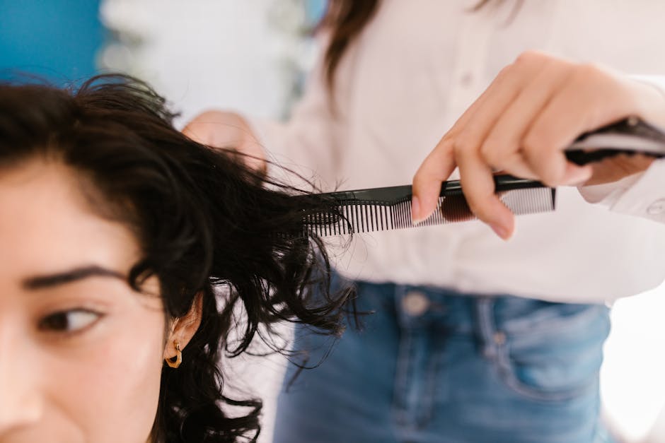 Close-up of hairstylist cutting client's hair in a salon setting
