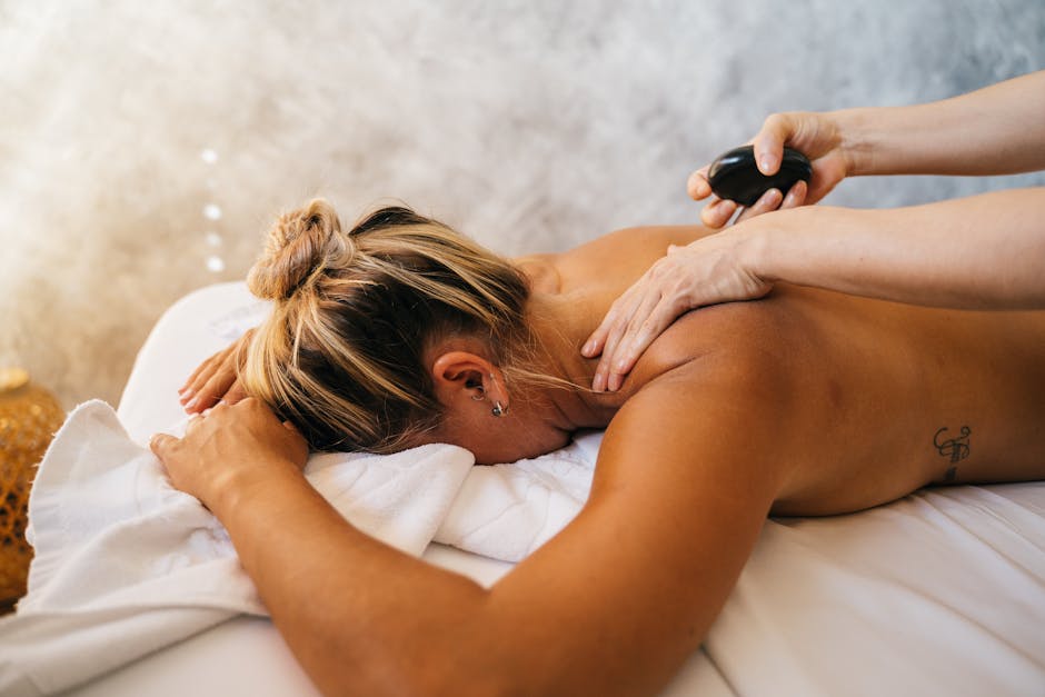 A woman enjoying a relaxing hot stone massage therapy session at a spa. Perfect for body care and relaxation