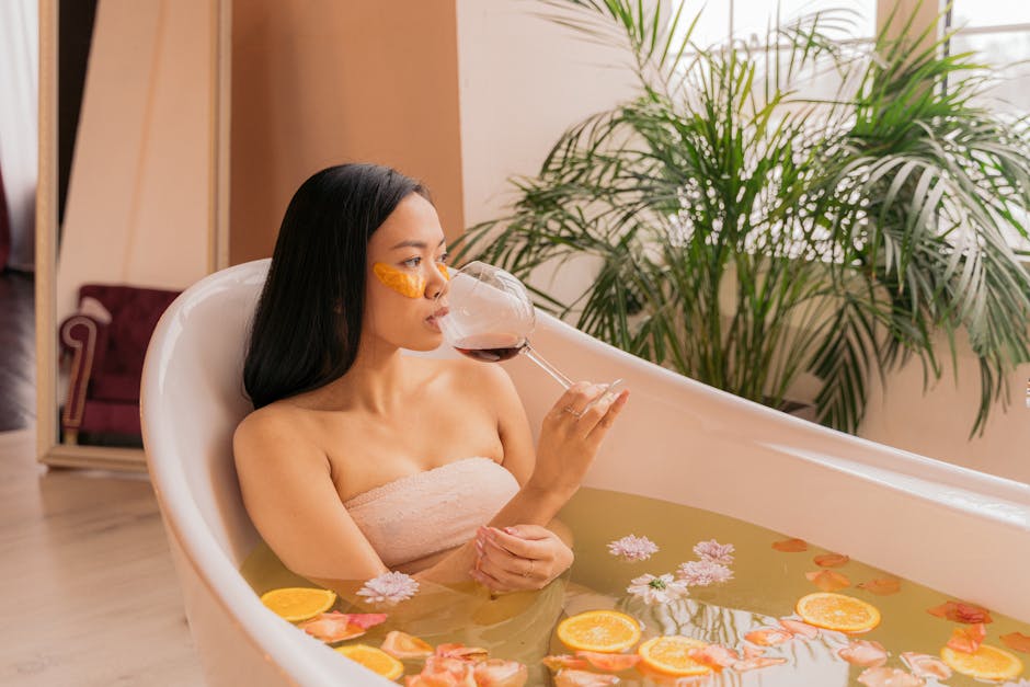 Woman enjoying a spa day with red wine and orange slices in a bathtub.